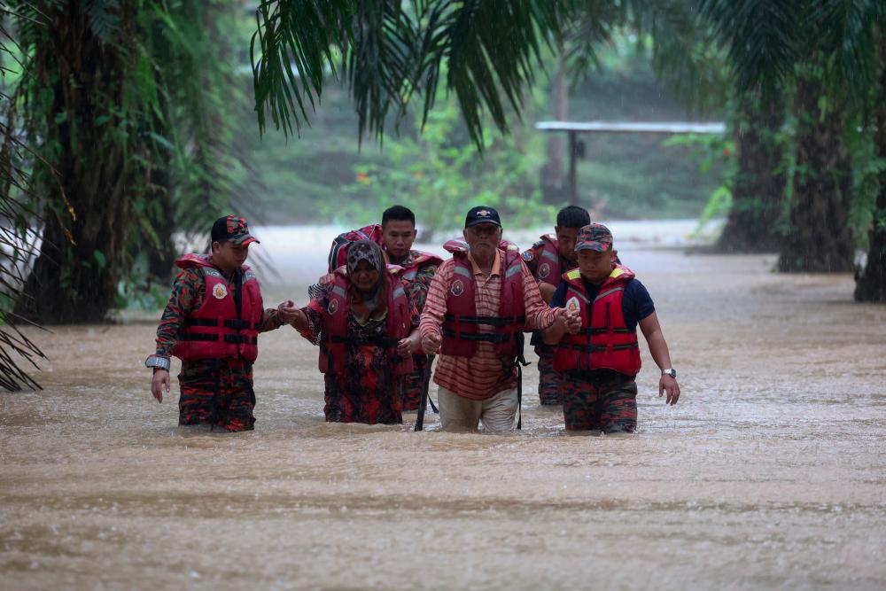 BELURAN, 15 Jan -- Anggota Bomba dan Penyelamat membantu warga emas Dockery Raymond, 75, (dua, kanan) dan isterinya Puan Rahilah, 68, (dua, kiri) meredah banjir untuk dipindahkan ke Pusat Pemindahan Sementara selepas rumah mereka terputus hubungan akibat banjir di Kampung Rancangan Cocos hari ini. - fotoBERNAMA