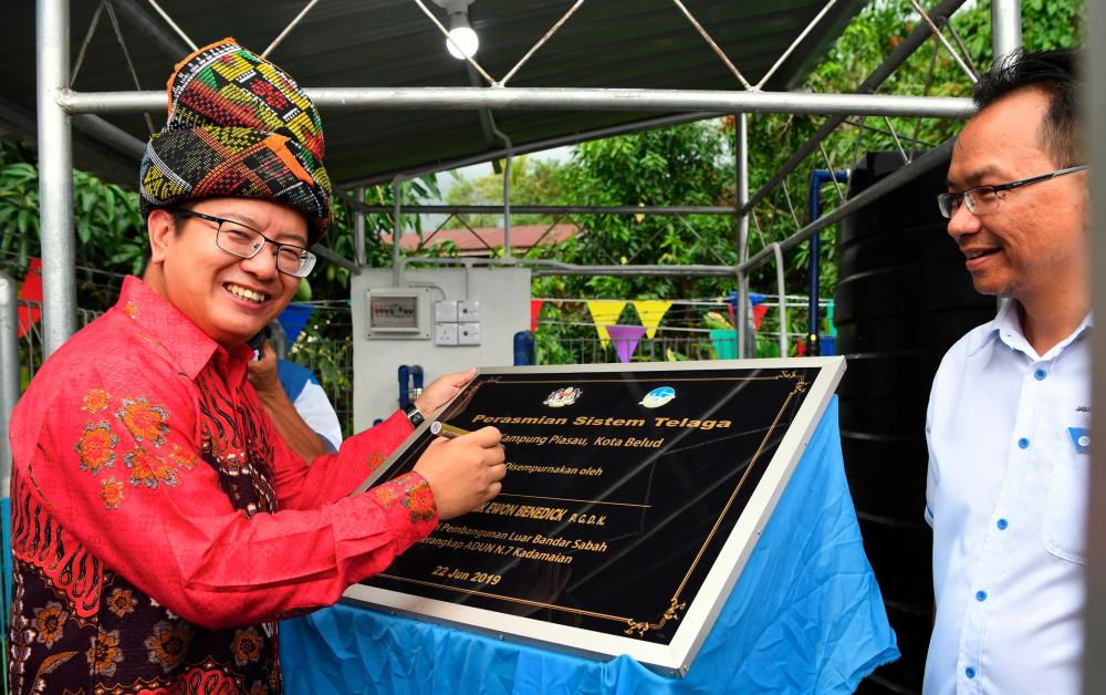 Sabah Rural Development Minister Datuk Ewon Benedick officially inaugurates the tube well and underground water filtration system at Kampung Piasau, near here today. - Bernama