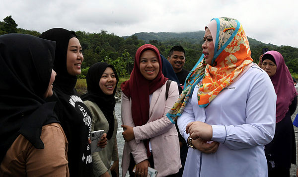 Rural Development Minister Datuk Seri Rina Mohd Harun (2, R) speaking to local tourists at Polumpung Melangkap, about 30 km away from Kota Belud, today. — Bernama