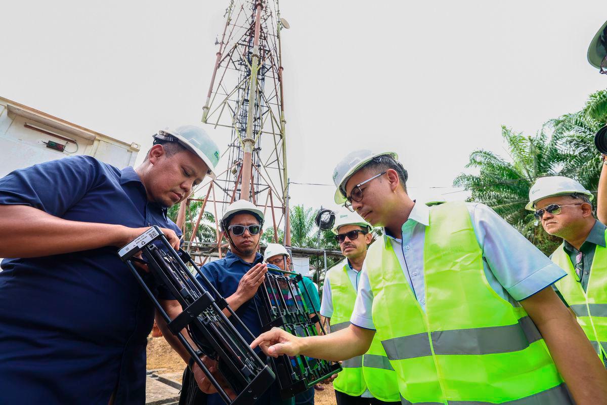 Menteri Komunikasi Datuk Fahmi Fadzil (kanan) menggunakan handy nemo untuk menguji kualiti liputan selular 4G dan 5G ketika melawat menara telekomunikasi Sapagaya sempena lawatan kerja beliau ke Tawau dan Lahad Datu hari ini. Turut hadir Ketua Setiausaha Kementerian Komunikasi Datuk Seri Mohamad Fauzi Md Isa (dua, kanan). - BERNAMA