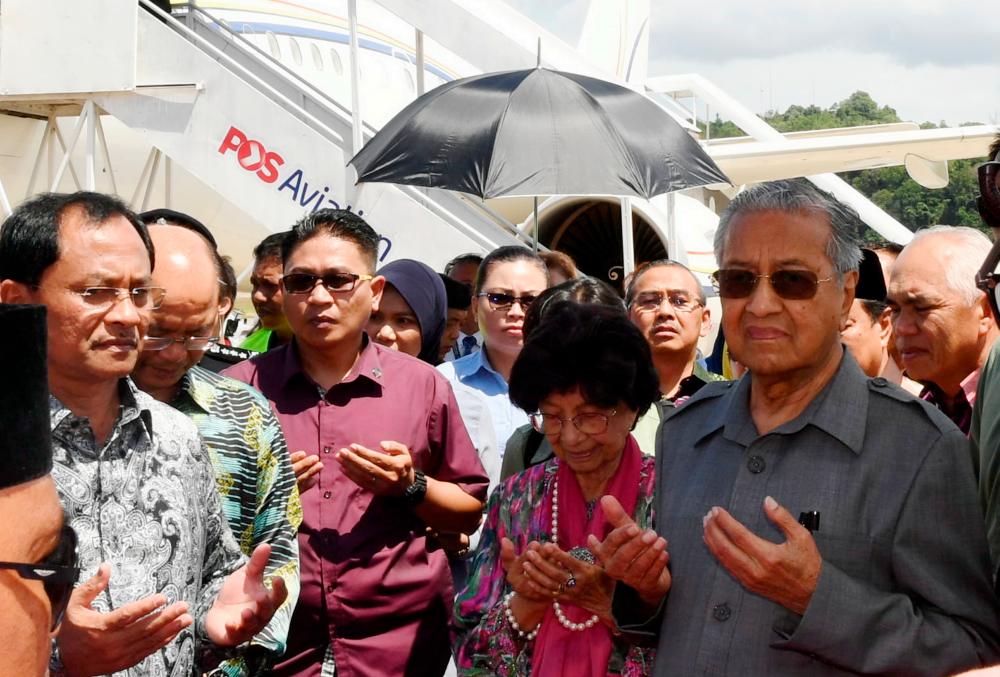 Prime Minister Tun Dr Mahathir Mohamad and his wife Tun Dr Siti Hasmah Mohamad Ali have a prayer reading after arriving at Terminal 2 of the Kota Kinabalu International Airport today. - Bernama
