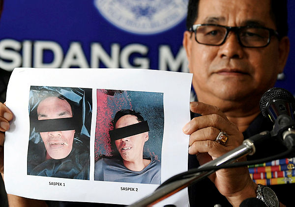 Sabah Police Commissioner Datuk Omar Mammah, holding up a picture of the two men who were shot dead by Esscom in Sabah Waters yesterday. — Bernama