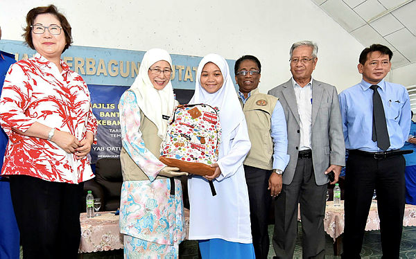 Deputy Prime Minister Datuk Seri Dr Wan Azizah Wan Ismail (2nd from L) hands over school baggage aid to students at the presentation of National Disaster Relief Aid for fire victims in Putatan, near Kota Kinabalu on Feb 8, 2019. — Bernama