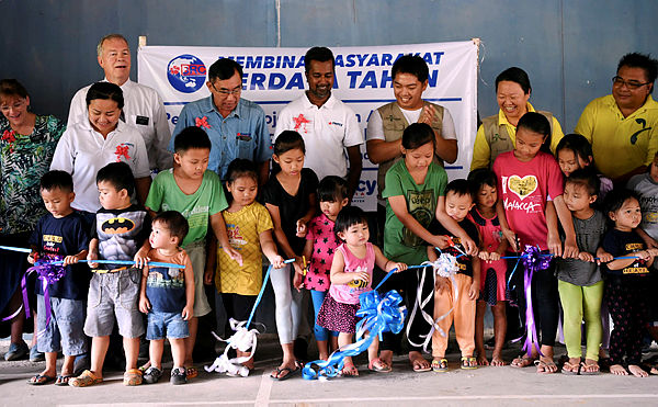 Children from Kampung Mengkulat cut the ribbon as part of the launch of the Kampung Mengkulat gravity water project at the community hall in Kota Belud on April 14, 2019. — Bernama