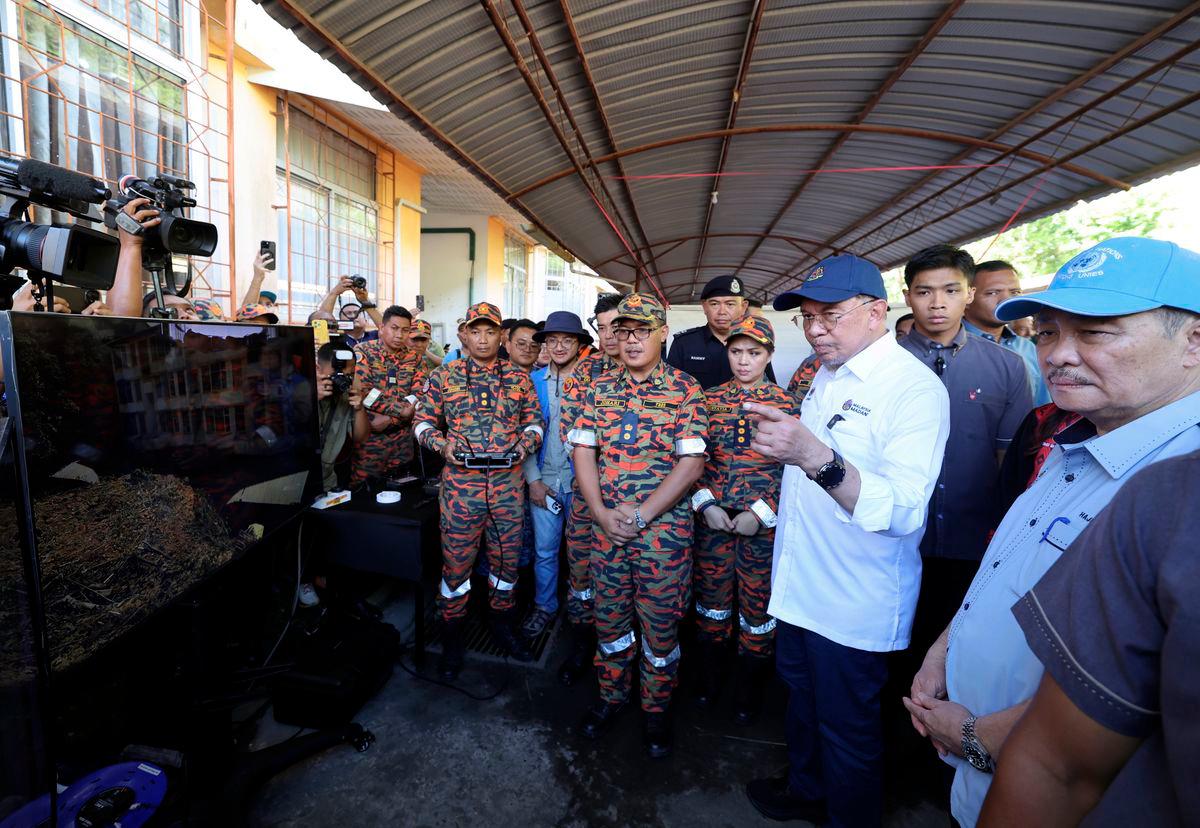 Perdana Menteri Datuk Seri Anwar Ibrahim ketika melakukan tinjauan lokasi tanah runtuh di Country Heights Penampang, hari ini. Turut hadir Ketua Menteri Sabah Datuk Seri Hajiji Noor (kanan) - fotoBERNAMA