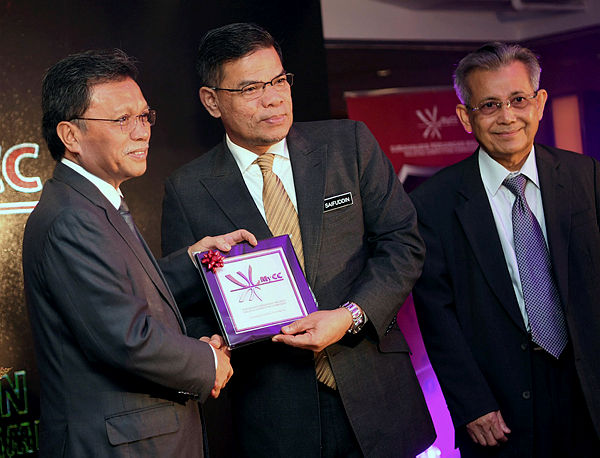 Sabah Chief Minister Datuk Seri Mohd Shafie Apdal (L) receives a gift from Domestic Trade and Consumer Affairs Minister Datuk Seri Saifuddin Nasution after opening the‘Say No to Tender Cheating Seminar’ organised by the Malaysia Competition Commission (MyCC), in Kota Kinabalu today. — Bernama