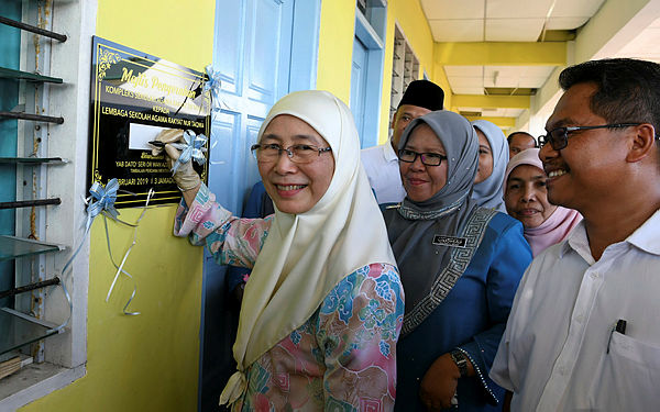 Deputy Prime Minister Datuk Seri Dr Wan Azizah Wan Ismail signs her signature on a plaque as a symbol of the inauguration of the Nur Taqwa-Sri Mulia religious school building complex in Kampung Rampayan Laut in Kota Belud on Feb 8, 2018. — Bernama