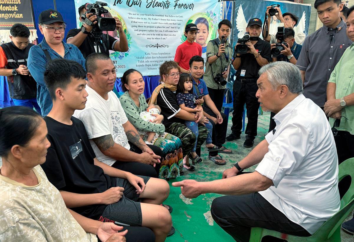 Timbalan Perdana Menteri Datuk Seri Dr Ahmad Zahid Hamidi ketika menyantuni keluarga mangsa tanah di Kampung Mook, Kinarut di sini, yang mengorbankan Emily Johnny, 38, dan anaknya Xarell Myre Aristothle, 11, dalam kejadian pada Isnin lepas. - BERNAMA