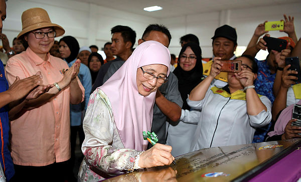 Deputy Prime Minister Datuk Seri Dr Wan Azizah Wan Ismail provides her signature for the opening of a disaster evacuation centre for Beaufort district on April 6, 2019. — Bernama