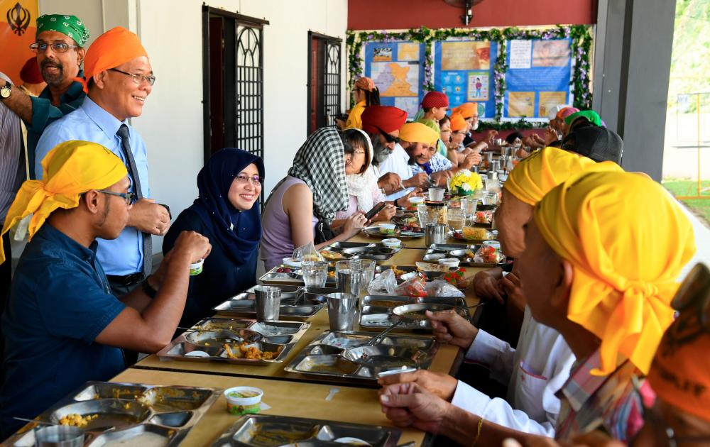 Assistant Minister to the Chief Minister Arifin Asgali (L) and members of the Sikh community attend the Guru Nanak Dev Ji’s 550th birthday at the Sikh worship hall in Kota Kinabalu today. - Bernama