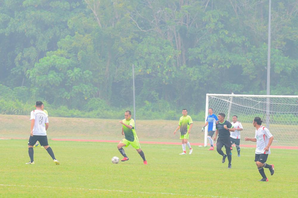 Footballers, unperturbed by the haze, continue to play at the Sandakan Sports Complex field, on Sept 14, 2019. — Bernama