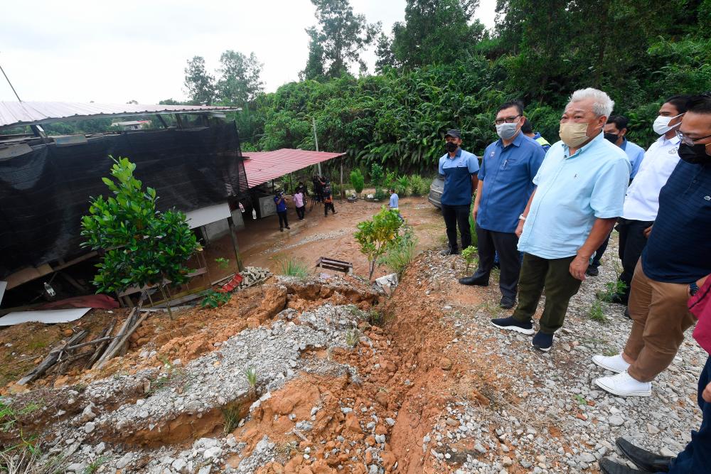 KINABATANGAN, 5 Jan -- Deputy Chief Minister and Works Minister Datuk Seri Bung Moktar Radin (center) sees the landslide that affected a resident’s house when visiting the district today. BERNAMApix