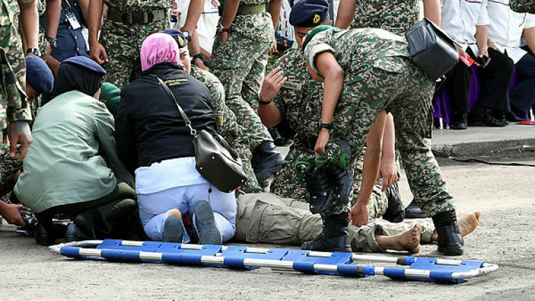 Army medics giving first aid to Major Mohd Zahir Armaya after he was shot during a gimmick at Lok Kawi Camp in Kota Kinabalu today. — Bernama