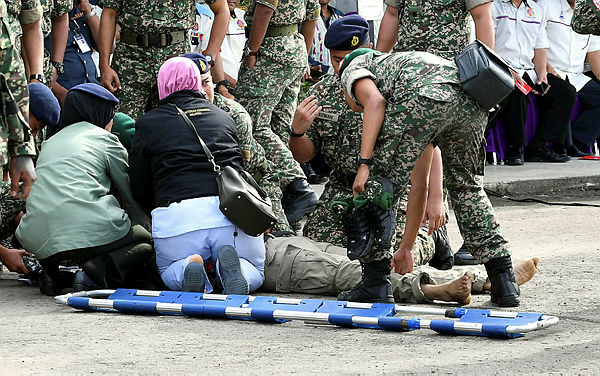 Army medics giving first aid to Major Mohd Zahir Armaya after he was shot during a gimmick at Lok Kawi Camp in Kota Kinabalu today. — Bernama