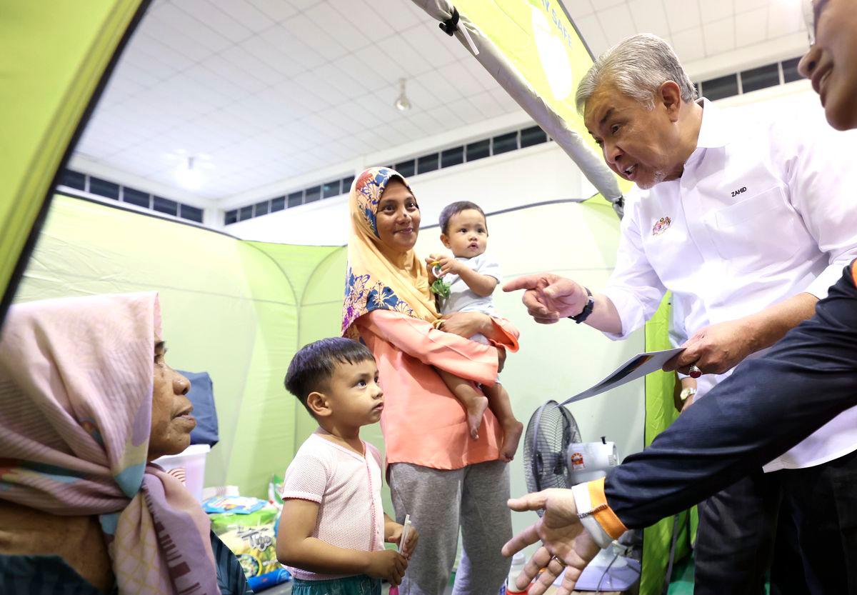 Timbalan Perdana Menteri Datuk Seri Ahmad Zahid Hamidi menyantuni mangsa banjir di Pusat Penempatan Sementara (PPS) Keramat Putatan,semalam- fotoBERNAMA