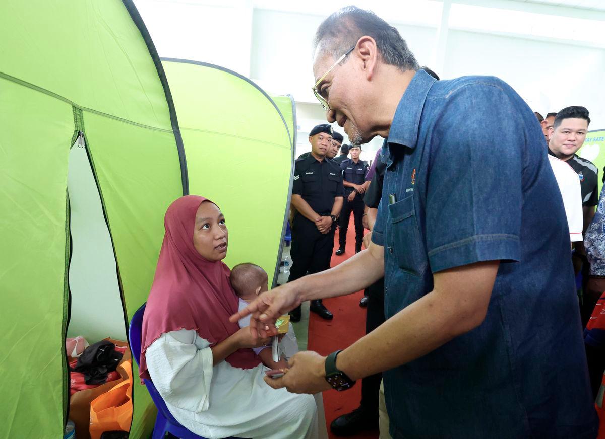 Menteri Kesihatan, Datuk Seri Dr. Dzulkefly Ahmad ketika melakukan lawatan ke Pusat Penempatan Sementara (PPS) Keramat Putatan hari ini. - BERNAMA