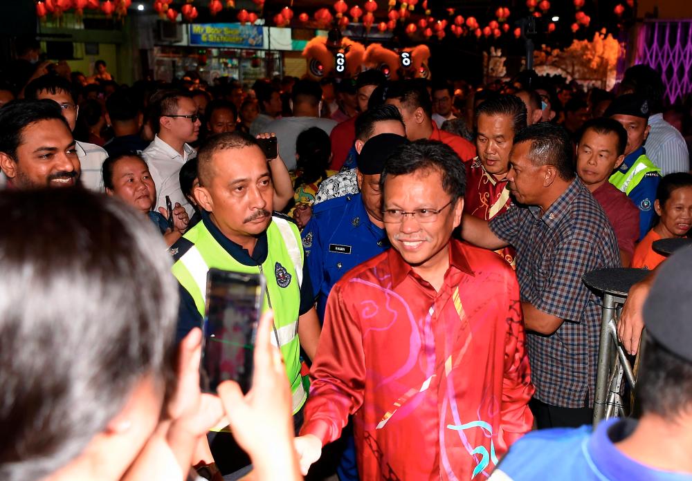 Sabah Chief Minister Datuk Seri Mohd Shafie Apdal shakes hands with the crowd during a Chinese New Year celebration event last night. - Bernama
