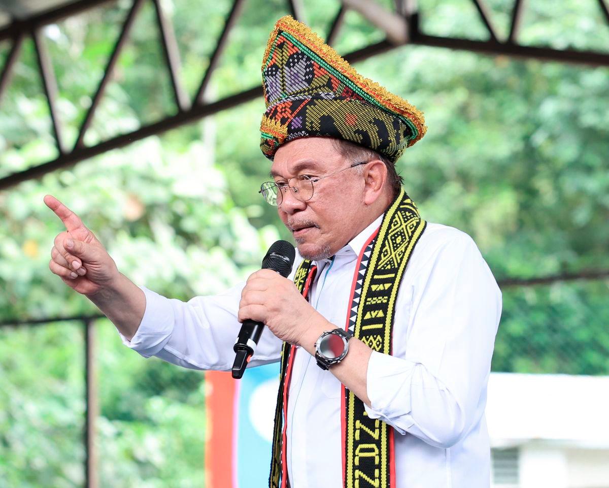 Perdana Menteri Datuk Seri Anwar Ibrahim berucap pada Program Rapat Umum dan Himpunan KEADILAN Sempena 27 Tahun Refomasi di Dewan Pisompuruan Kampung Kobuni Inanam hari ini. - BERNAMA