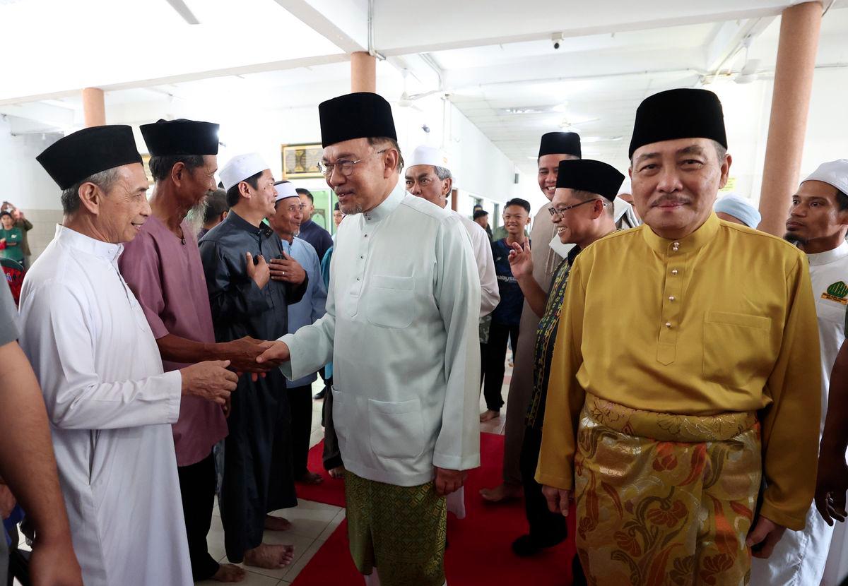Perdana Menteri Datuk Seri Anwar Ibrahim bersalaman dengan orang ramai ketika tiba untuk menunaikan Solat Jumaat di Masjid Nurul Hikmah hari ini.Turut sama Ketua Menteri Sabah Datuk Seri Hajiji Noor. - fotoBERNAMA