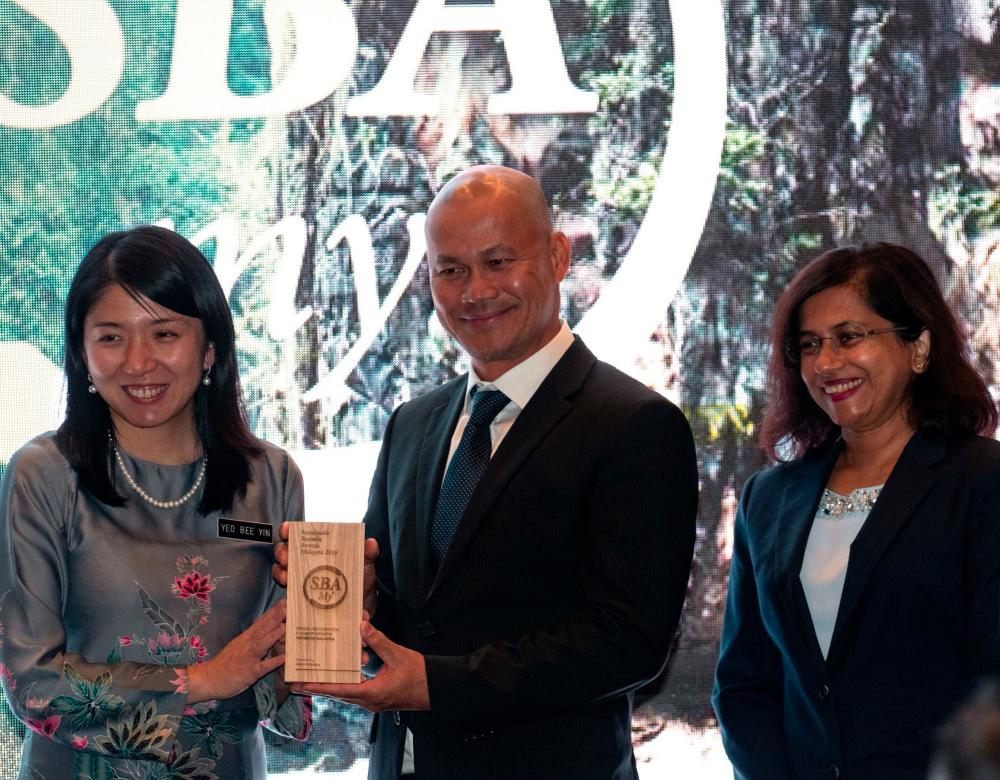 Minister of Energy, Science, Technology, Environment and Climate Change Yeo Bee Yin presents the award to Bala and Renuka.