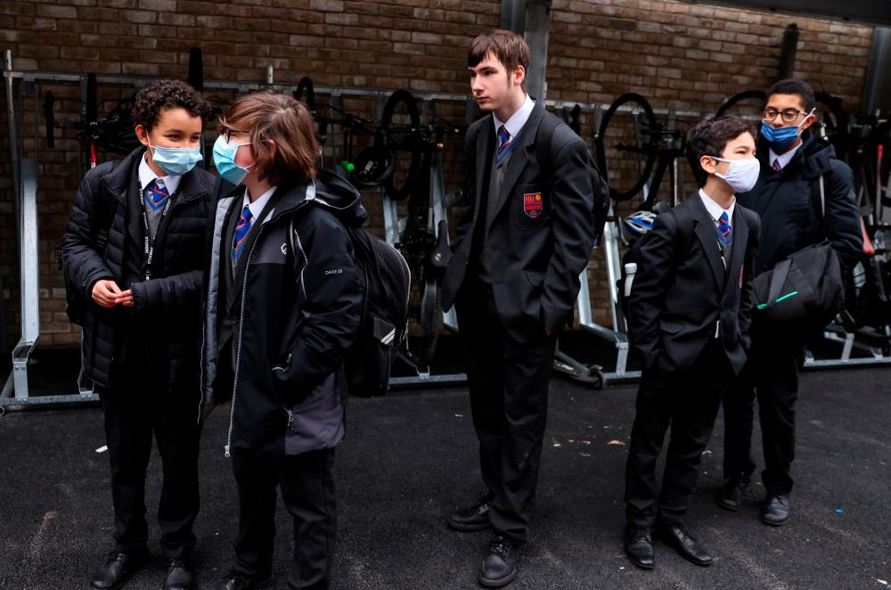 Students arrive for the first day back at school, as the coronavirus disease (Covid-19) lockdown begins to ease, at Fulham Boys School in London, Britain, March 8, 2021. — Reuters