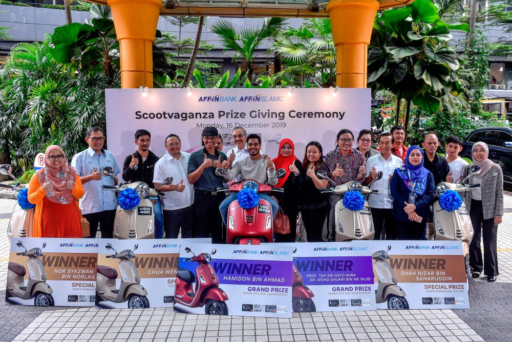 Affin Bank Bhd chairman Datuk Agil Natt (centre, back) dan Affin Bank card ambassador singer Alif Satar (centre, front) with winners of the ‘Scootvaganza is Back’ campaign at the presentation ceremony today. – BERNAMAPIX