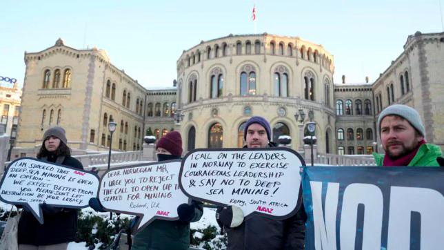 Protesters hold placards during a demonstration against seabed mining outside the Norwegian Parliament building in Oslo - AFPPIX