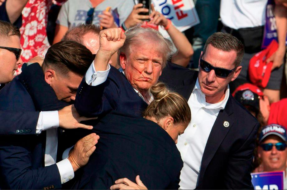 Republican candidate Donald Trump is seen with blood on his face surrounded by secret service agents as he is taken off the stage at a campaign event at Butler Farm Show Inc in Butler, Pennsylvania, July 13, 2024. -AFPpix