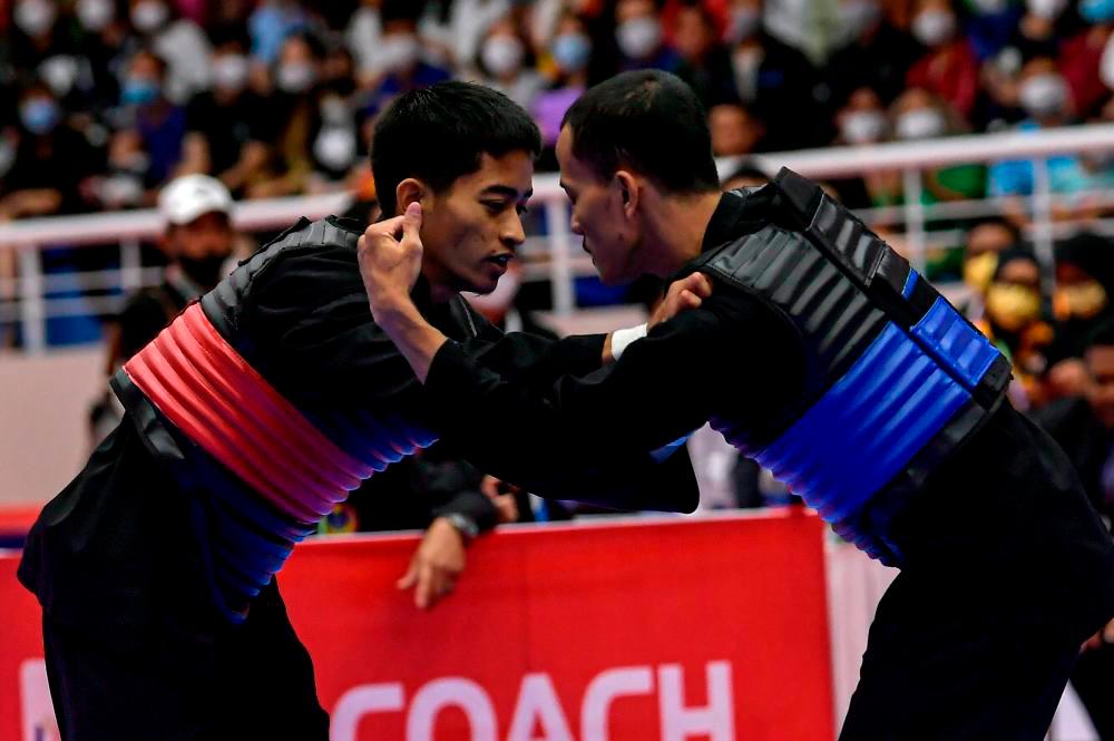 HANOI, May 16 2022-Malaysian wrestler Muhammad Khairi Adib Azhar (left) when facing Indonesian wrestler Khoirudin Mustakim in the final of the Men’s Category B Silat Tanding at the 31st SEA Games at the Bac Tu Leim Sports Center Silat Court. BERNAMAPIX