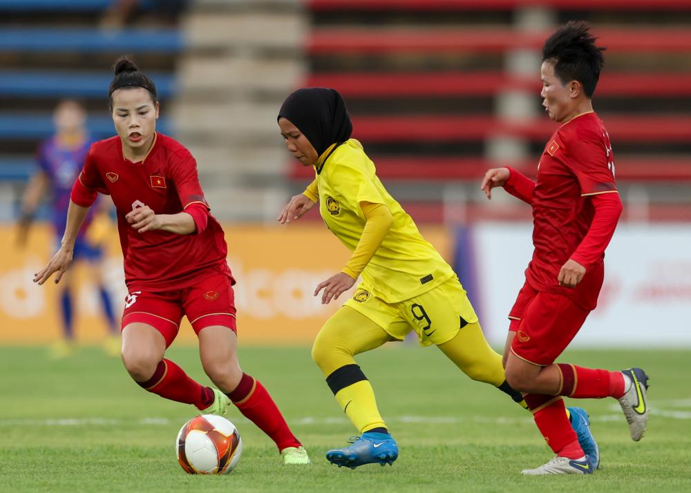 PHNOM PENH, May 3 -- Malaysian women’s soccer player Nur Lyana Soberi (second, left) is pushed by two Vietnam Team players during the Group A Women’s Soccer match at Army Stadium Phnom Penh at the 2023 SEA Games in Phnom Penh, Cambodia today. BERNAMAPIX