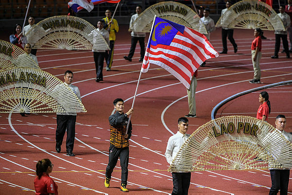 Loh Jack Chang, former Malaysian wushu athlete carries the Malaysian flag at the SEA Games 2019 closing ceremony in New Clark City yesterday — Bernama