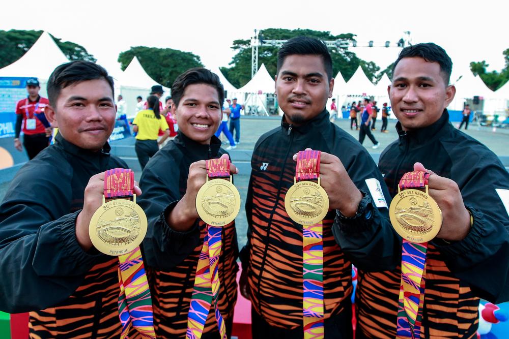 Malaysian petanque athletes (from left) Syed Akmal Fikri Syed Ali, Saiful Bahri Musmin, Muhammad Hafizuddin Mat Daud and Mohd Safi showing gold medals won in petangue men’s triples final at the CDC Lot in front of the Royce Hotel and Casino, Clark for 30th SEA Games, Dec 5, 2019. — Bernama