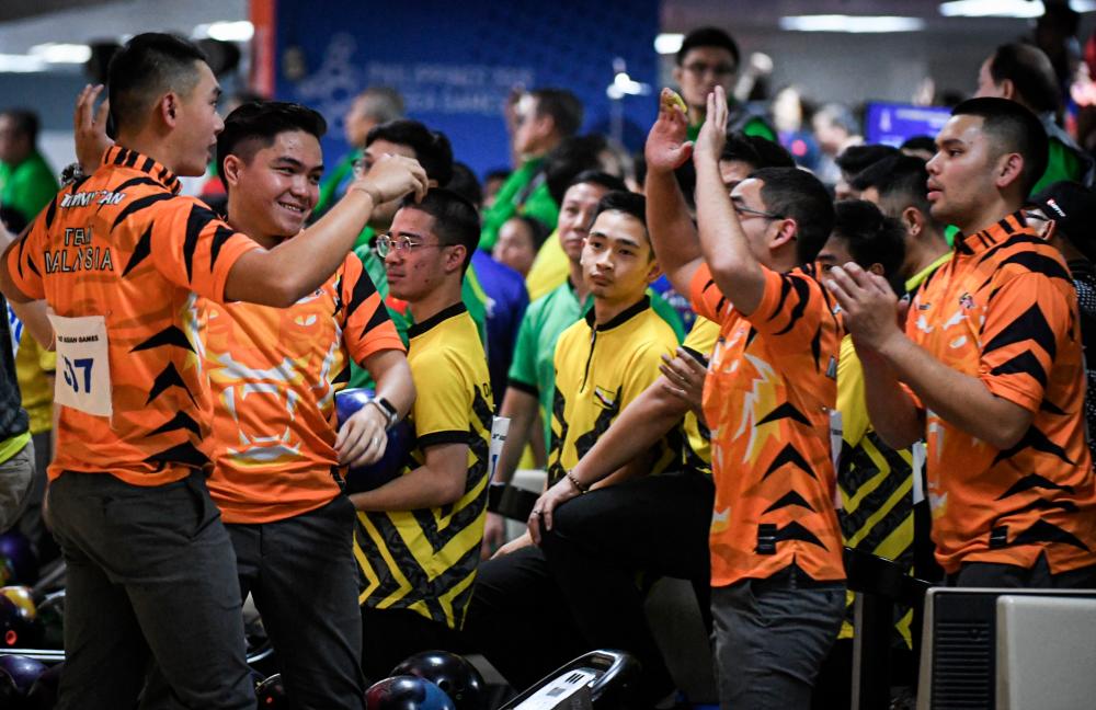 The national tenpin bowling team celebrates clinching the gold modal, at the 30th SEA Games in the Philippines, on Dec 6, 2019. — Bernama