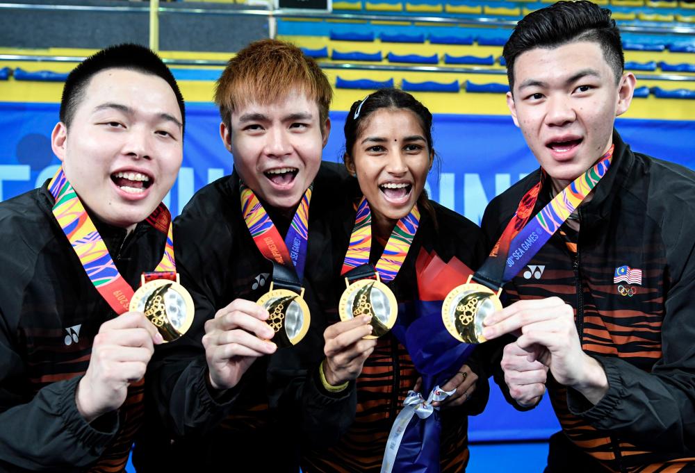 Badminton athletes (from left) Aaron Chia, Soh Wooi Yik, Kosina Selvaduraj and Lee Zii Jia showing the gold medals won on the ninth day of competition at the 30th SEA Games on Dec 9. — Bernama