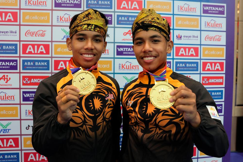 PHNOM PENH, May 7 -- National martial artists who are also twins Muhammad Danial Azrol Noorazizan (right) and Muhammad Danial Azray Noorazizan show off the gold medal they won in the Silat Seni Ganda event at the 2023 SEA Games at the Chroy Changvar Convection Center yesterday. BERNAMAPIX