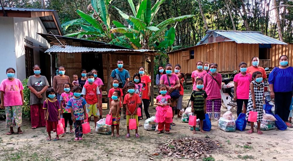 Orang Asli families taking a group photo after receiving daily necessities from Sports Toto.