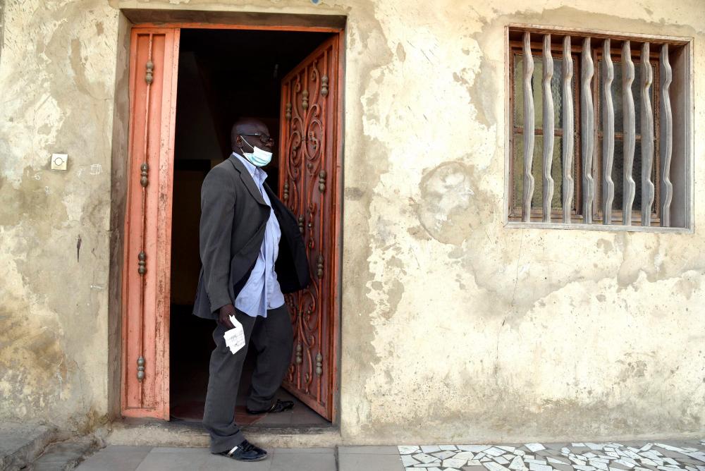 In this photograph taken on April 24, 2020, family head Tidiane Konte, who is in receipt of money transfers sent by his brother who lives in Spain, stands in a doorway at his home in Keur Massar on the outskirts of Dakar. — AFP