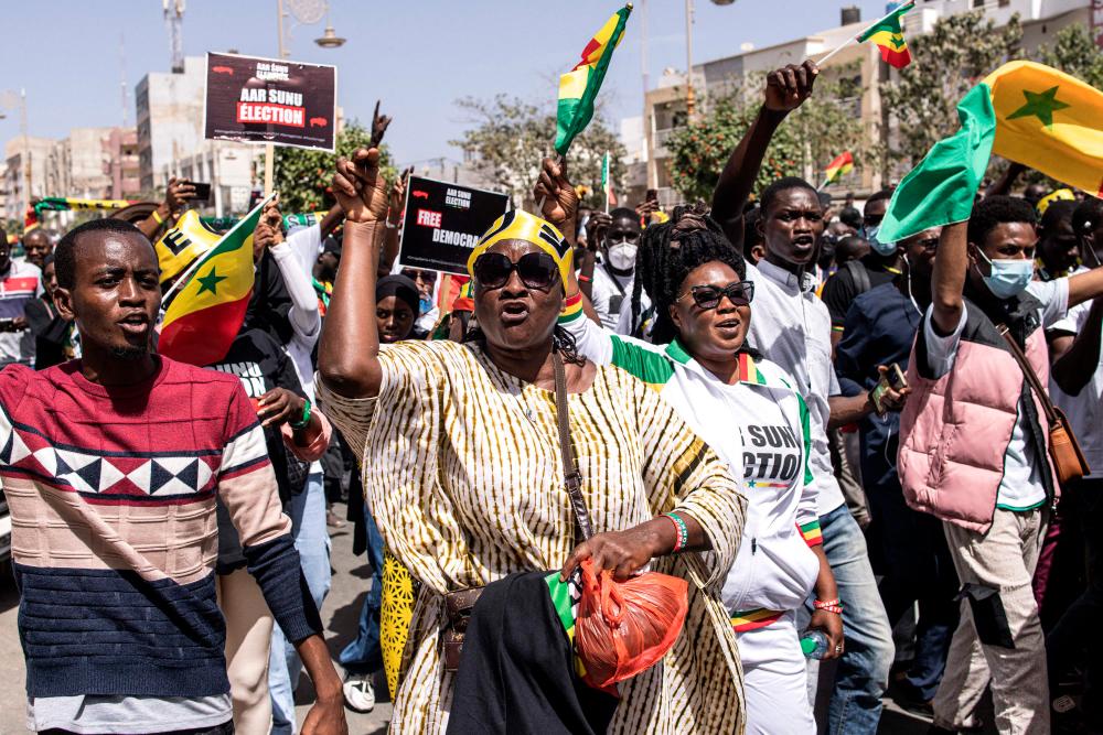 Civil society groups and political groups hold placards as they march calling on authorities respect the election date, in Dakar, on February 17, 2024/AFPPix