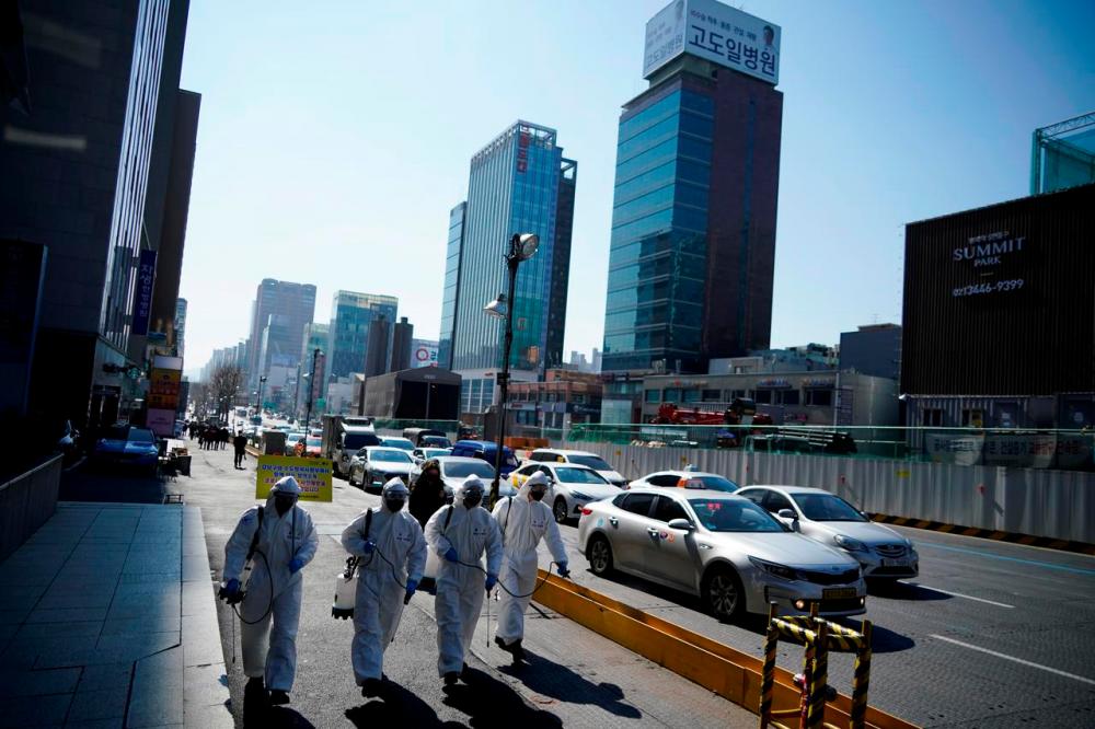 South Korean soldiers in protective gear sanitize a street in Seoul, South Korea, March 5, 2020. — Reuters