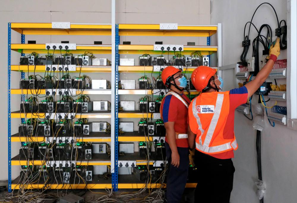 TNB employees investigate power cuts related to electricity theft and cryptocurrency business in Port Klang today. - Bernama