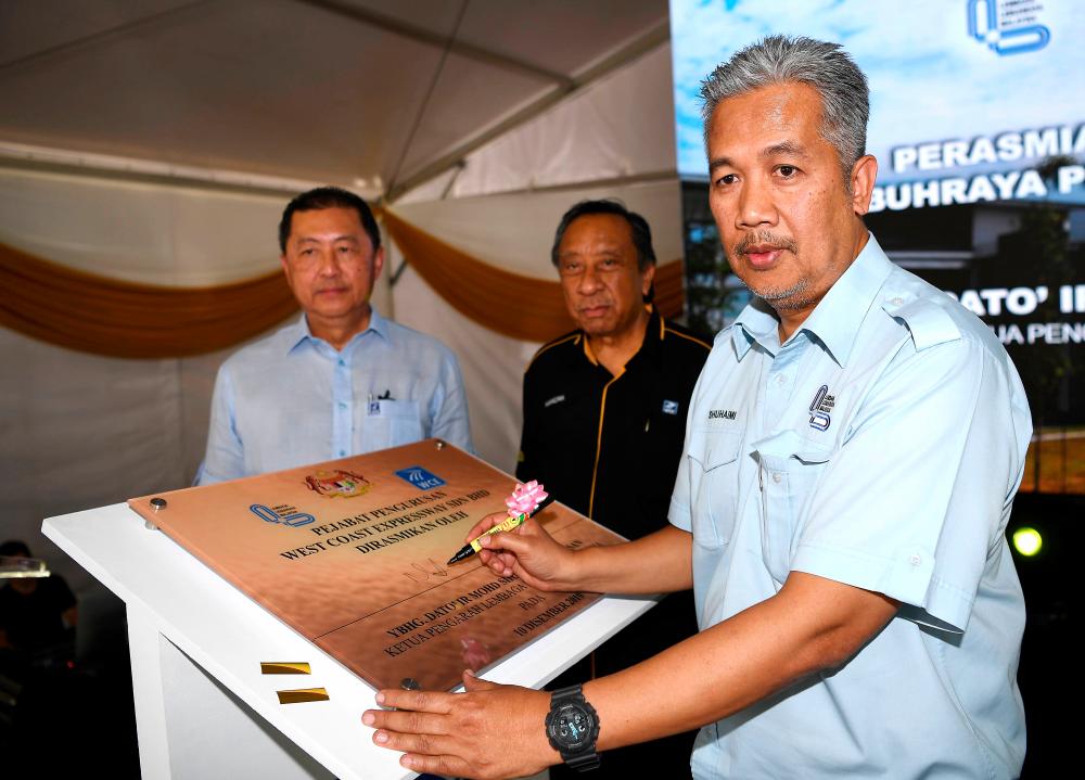 Malaysian Highway Authority director-general Datuk Ir Mohd Shuhaimi Hassan (R) signs the inaugural plaque of the West Coast Expressway at the opening of the interchange and the WCE management office in Klang today. - Bernama