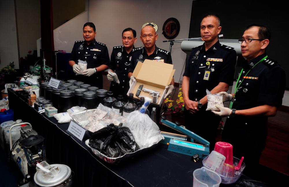 Selangor deputy police chief Datuk Arjunaidi Mohamad (3rd from R) with officers display seized firearms, drugs of various types and drug processing equipment, at a press conference at the Selangor contingent police headquarters today. - Bernama