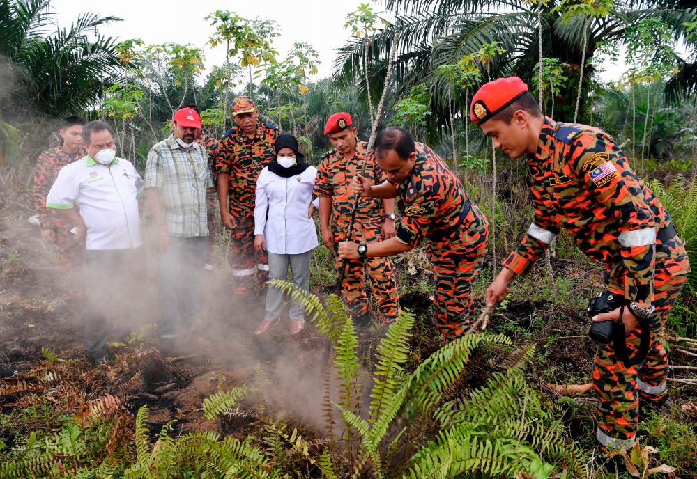 Deputy secretary-general of the Ministry of Energy, Science, Technology, Environment and Climate Change (Mestecc), Dr K Nagulendran (2ndL), with deputy director-general (Development) of the Department of Environment (DoE) Norhazni Mat Sari (4thR) and Selangor DoE director Shafee Yasin (L), at an open burning site in Johan Setia, on Sept 14, 2019. — Bernama