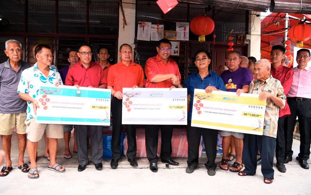 Litrak CEO Sazally Saidi (5th from L) presents a replica cheque in conjunction with the Chinese New Year celebration at the Rumah Sejahtera, Jenjarom today. - Bernama