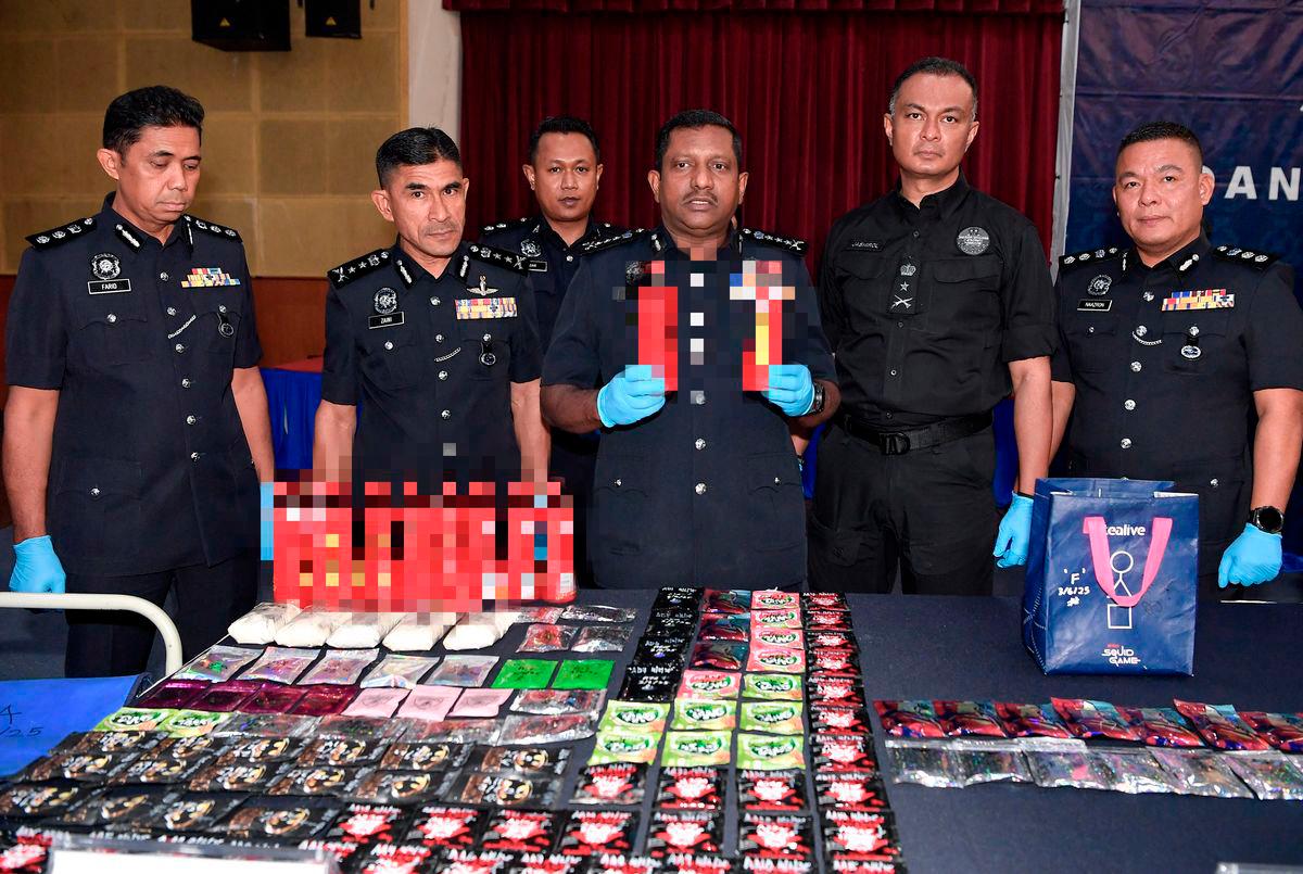 Ketua Polis Selangor Datuk Hussein Omar Khan (tiga, kanan) menunjukkan minuman yang mengandungi dadah ketika sidang media berhubung kejayaan anggota polis menumpaskan sindiket pengedaran dadah dikenali “Geng Alstonia” di Ibu Pejabat Polis Kontinjen Selangor hari ini. fotoBERNAMA