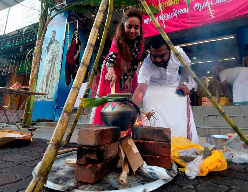 A couple prepare the Ponggal (sweet rice) for Ponggal celebration in Klang, on Jan 15, 2019. — Bernama