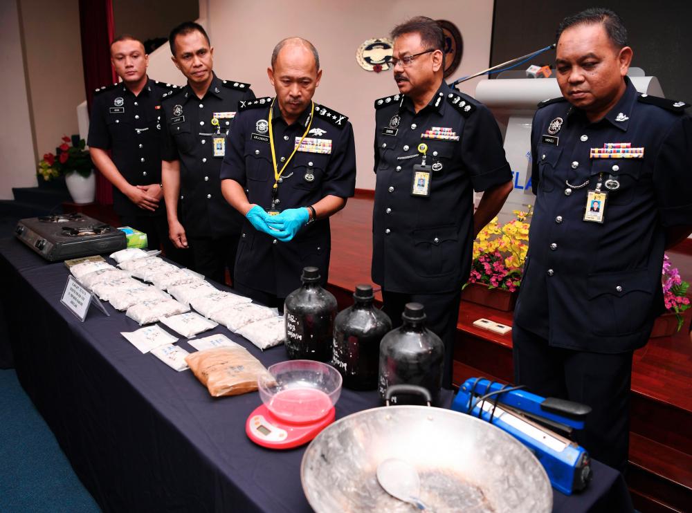 Selangor deputy police chief Datuk Arjunaidi Mohamed (C) and other senior police officials display the RM119,000 worth of heroin and other drugs seized from an illegal drug lab syndicate in South Klang, during a press conference at the Selangor police headquarters in Shah Alam on Oct 22, 2019. - Bernama