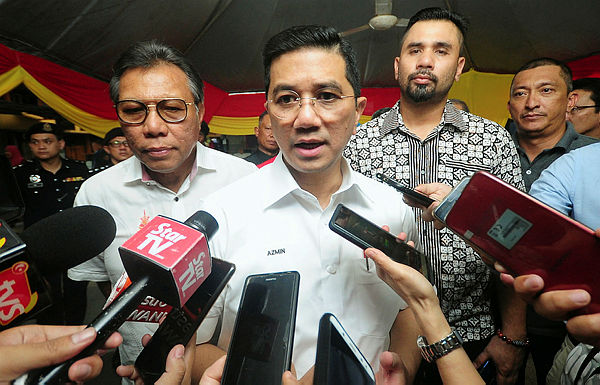 Economic Affairs Minister Datuk Seri Mohamed Azmin Ali (centre) speaking to eporters after presenting his ministry’s allocations to 10 schools for infrastructure repair projects in Klang. — Bernama