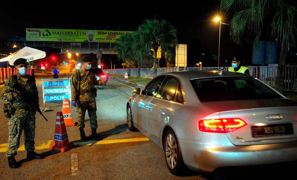 Officers from the Malaysian Armed Forces, during a road block as part of the enforcement of the Movement Control Order (MCO), in Sekysen 7, Shah Alam, on April 1, 2020. — Bernama