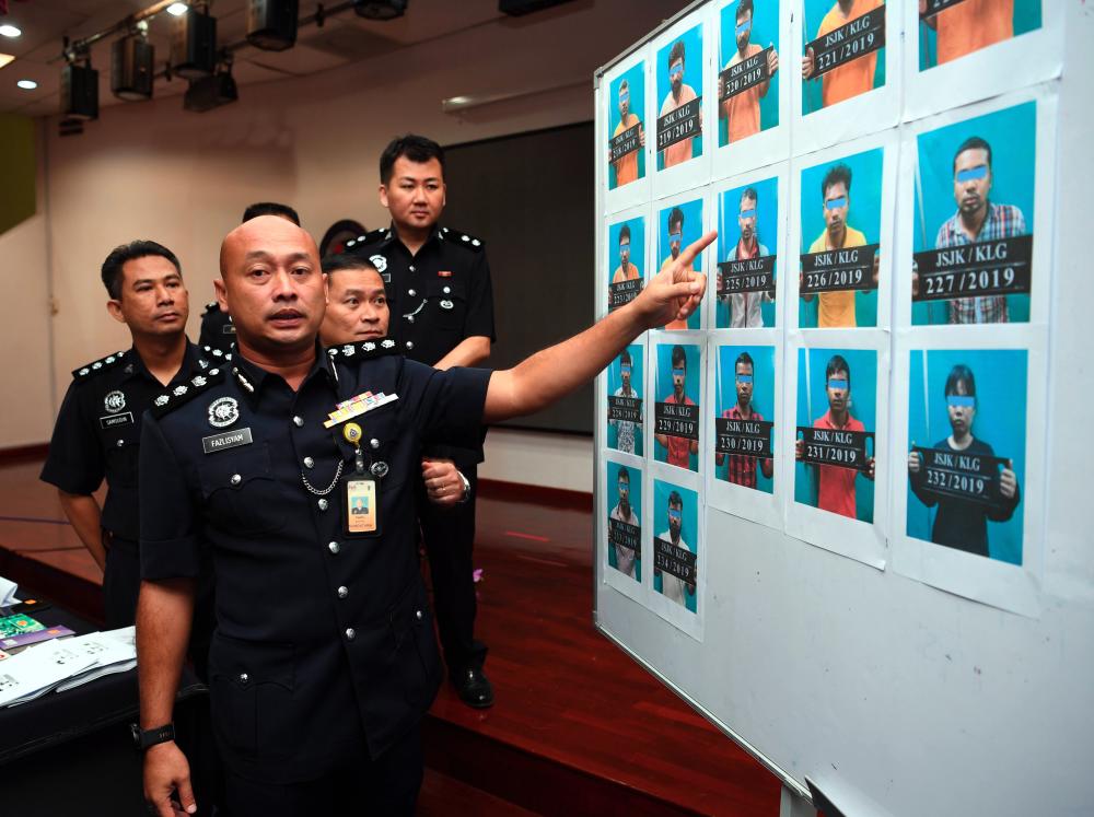 Selangor Commercial Crime Investigation Department chief ACP Faz Inglesam Abd Majid displays the pictures of syndicate suspects at a press conference at the Selangor police headquarters in Shah Alam today. - Bernama
